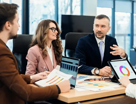 Managers discussing documents around a meeting table