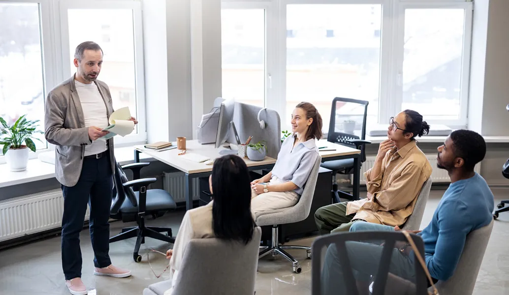 Team leader presenting to colleagues in a bright office